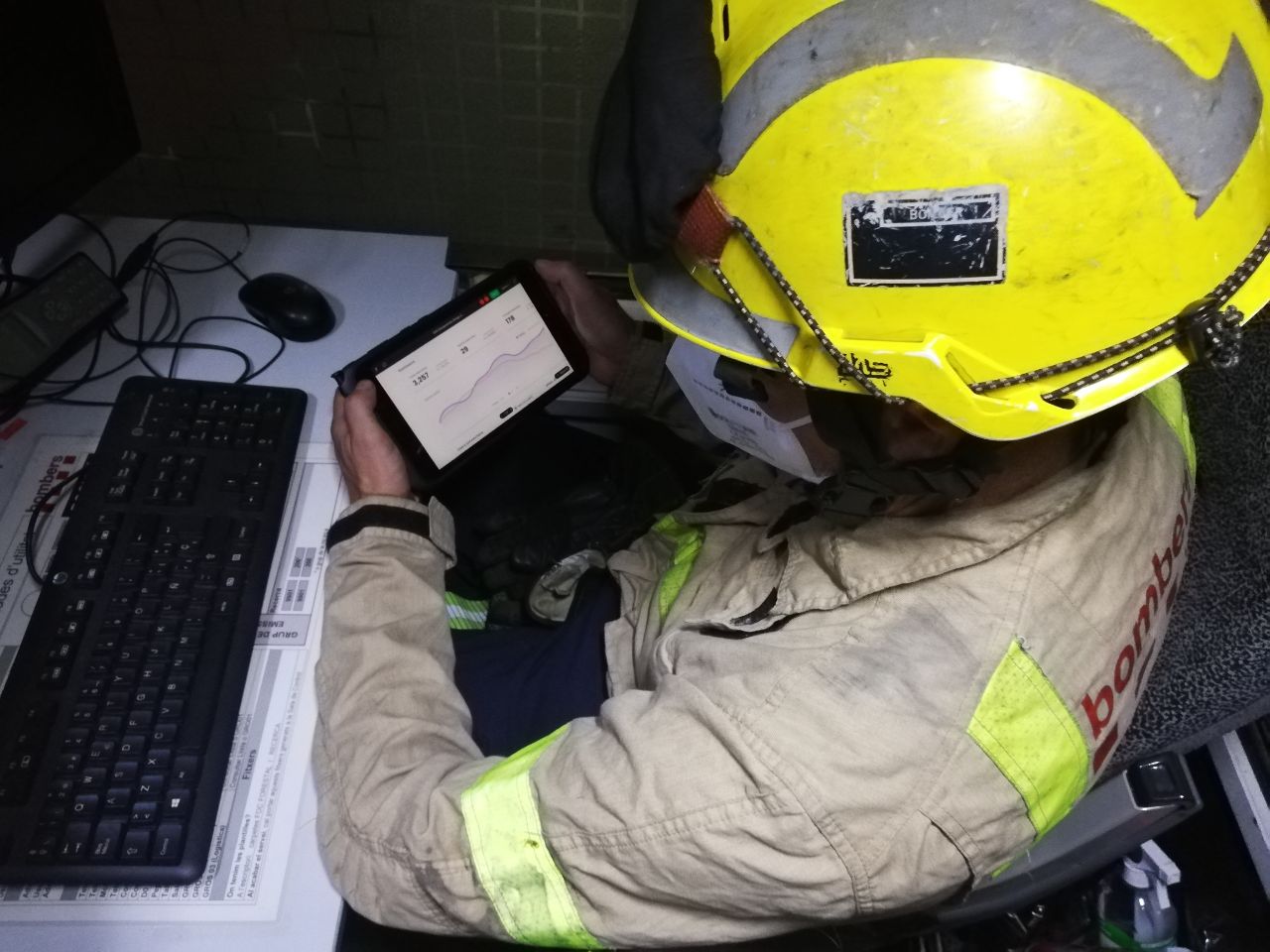 A firefighter in gear using the app on a tablet at a desk