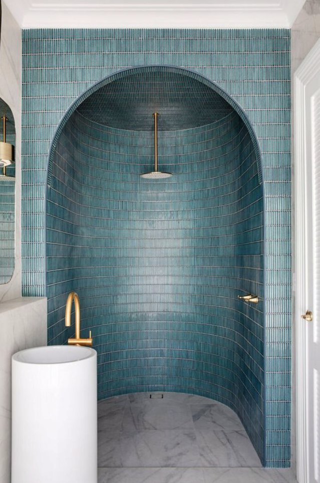 Arched shower niche in teal tile