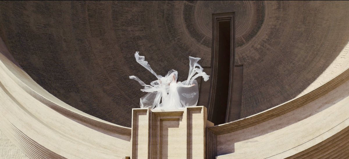 Veiled figure beneath a concave dome