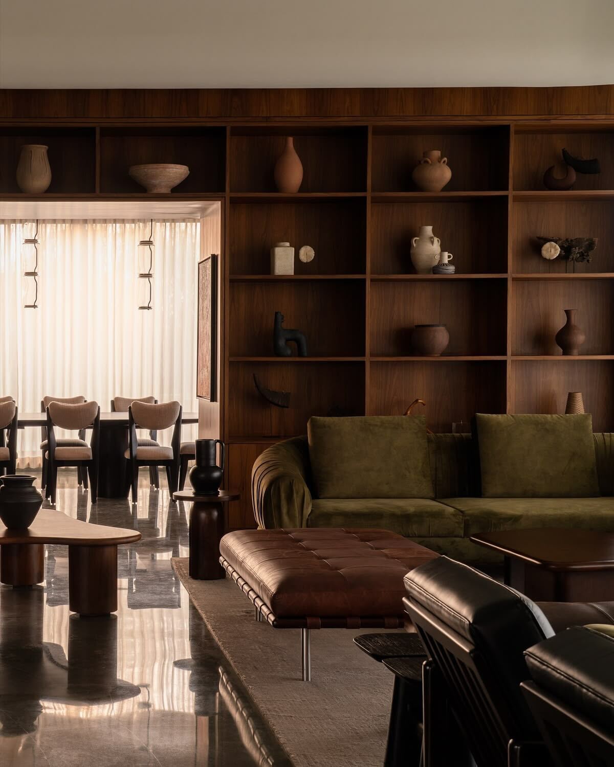 Walnut shelving wall, olive sofa