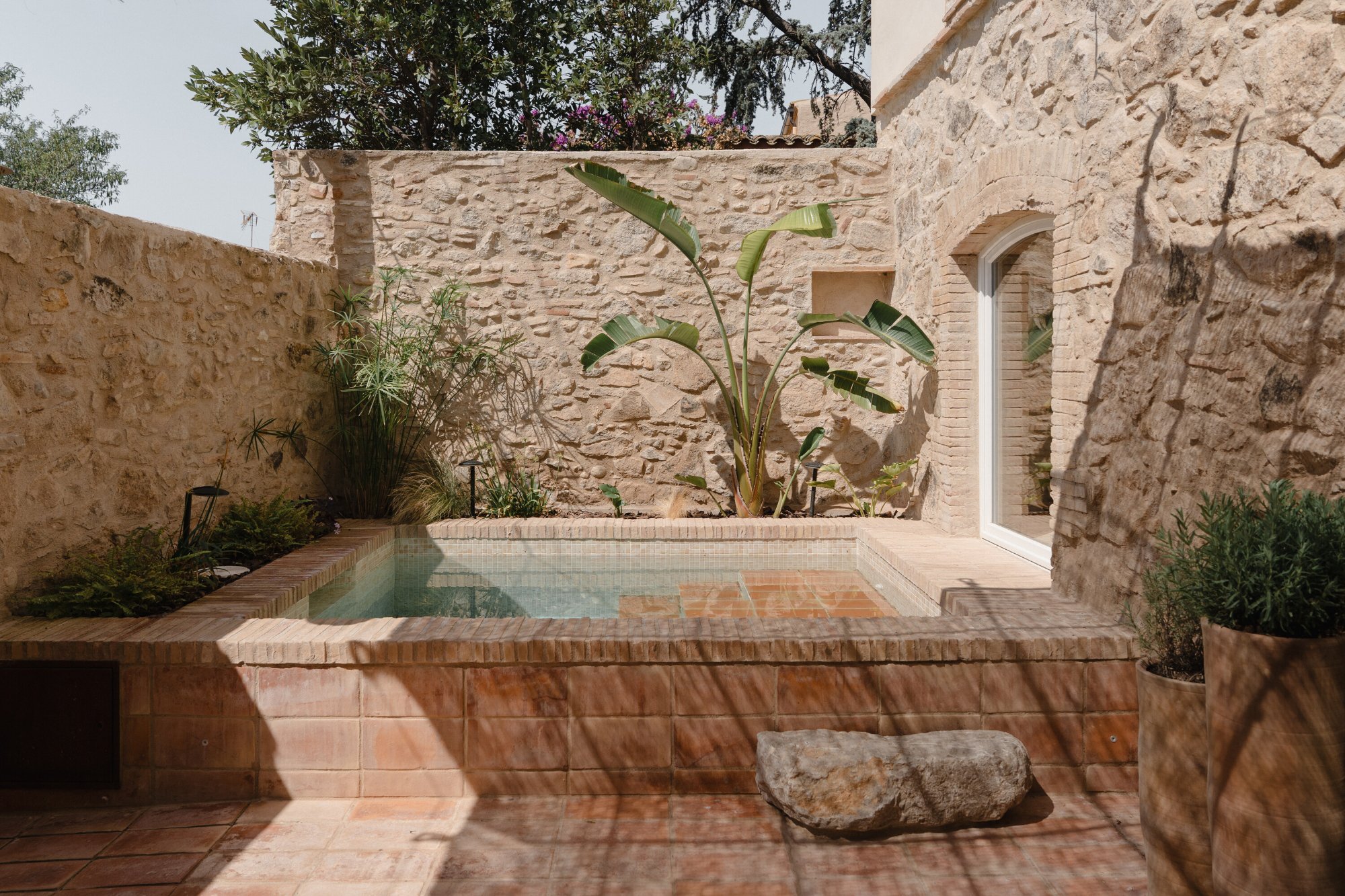 Terracotta plunge pool in a stone courtyard