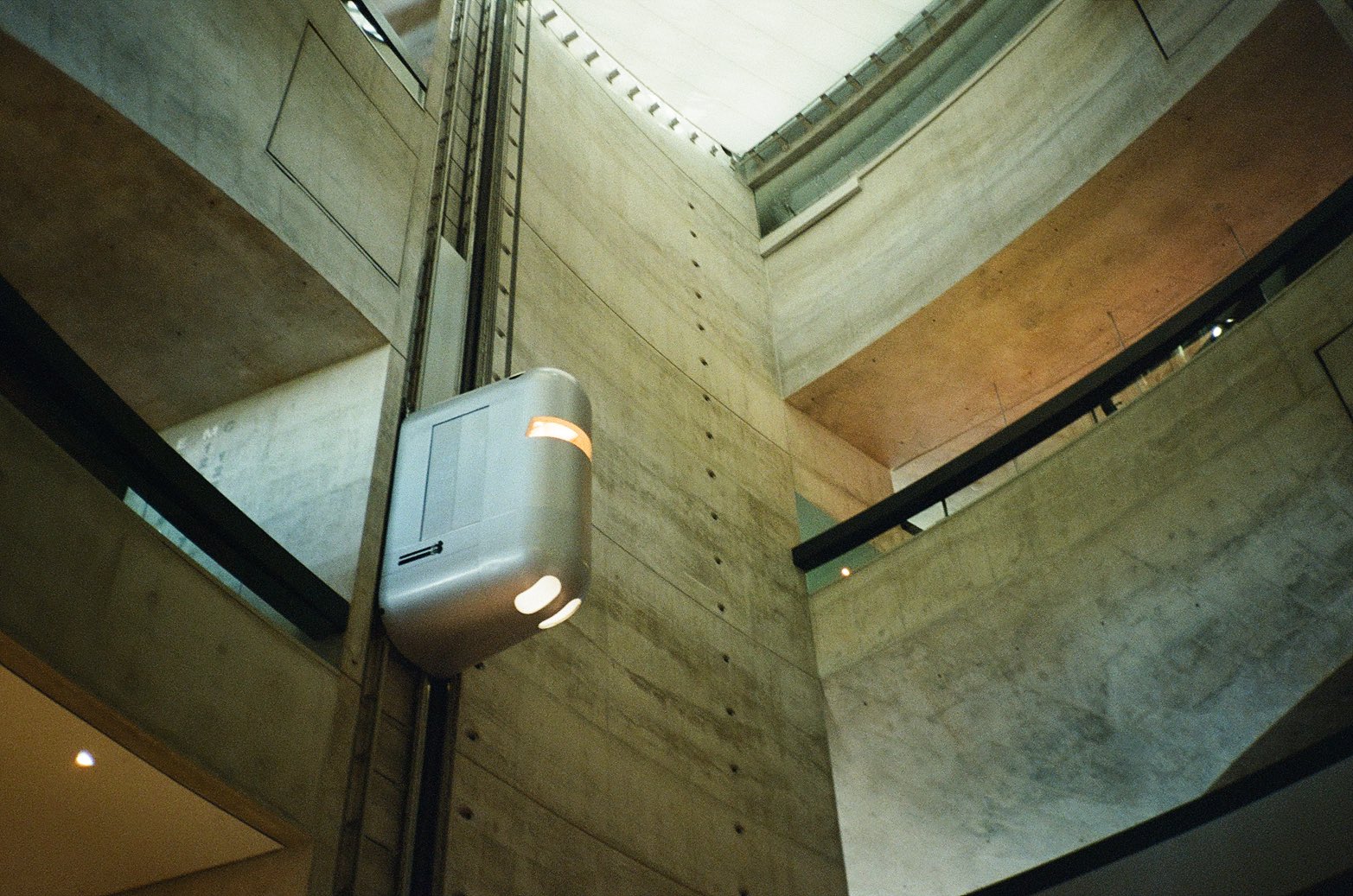 Capsule lift in a concrete atrium